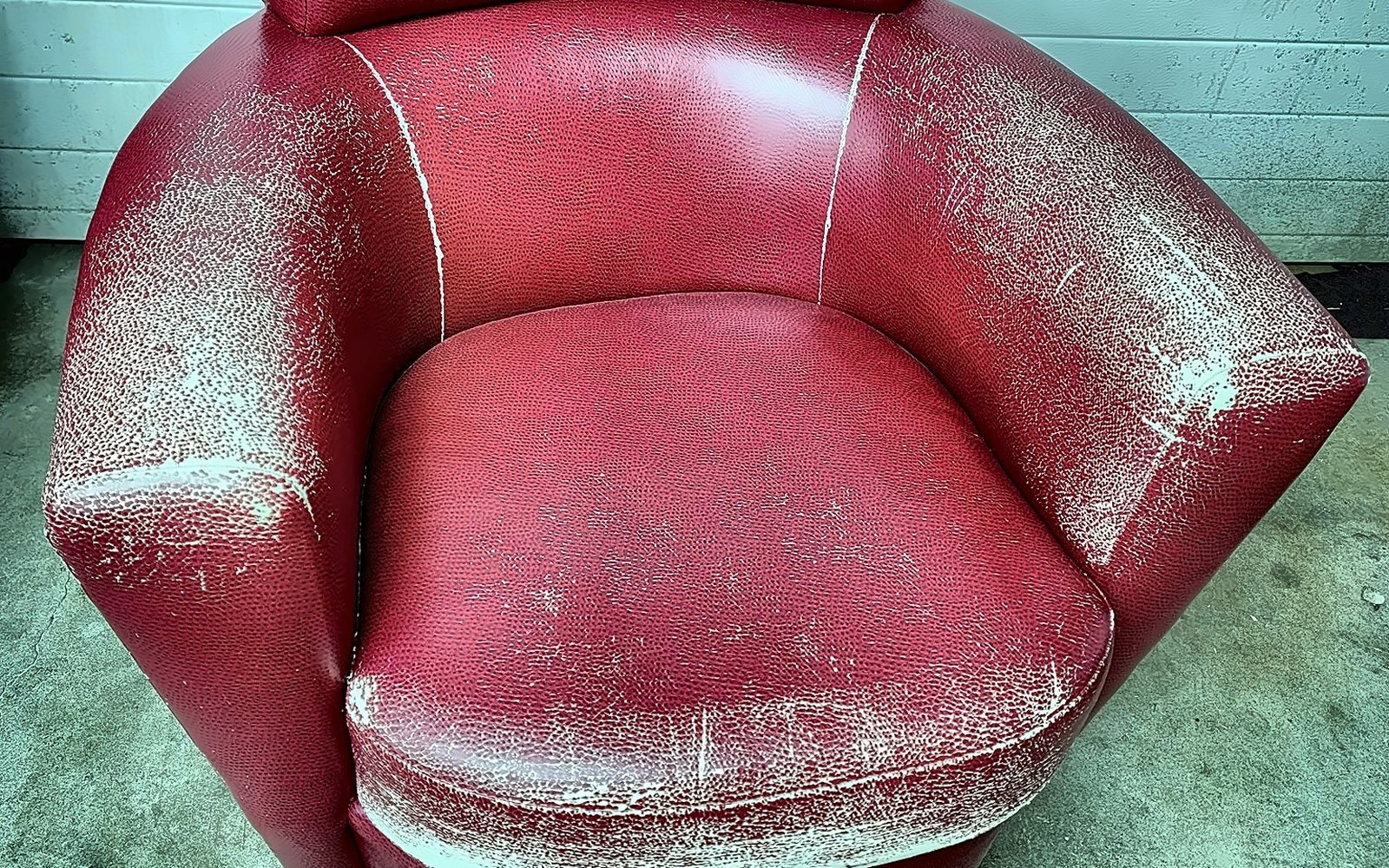 Red leather swivel chair worn and cracked — before